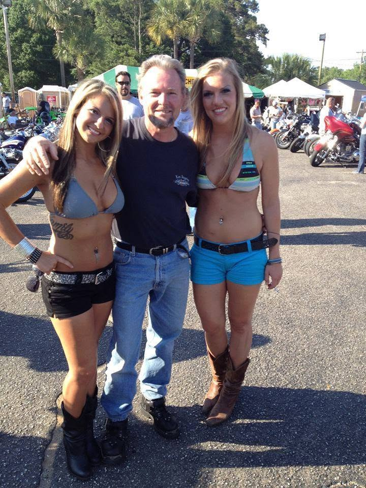 Michael Agee posing with two women among motorcycles at Myrtle Beach Bike Week.